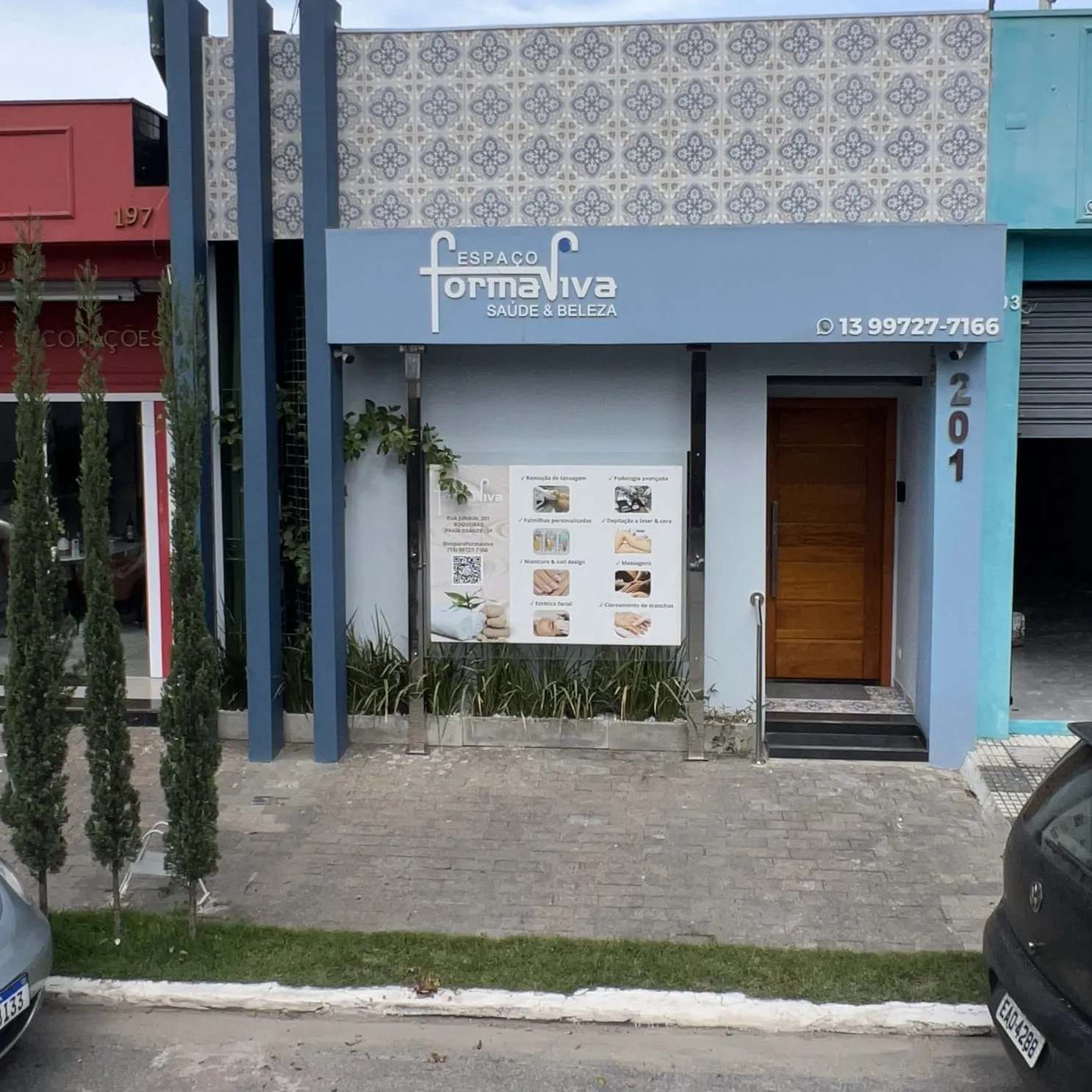 A fachada azul do Espaço Forma Viva vista da calçada da R. Jundiaí, 201, em Praia Grande, entre as lojas vizinhas